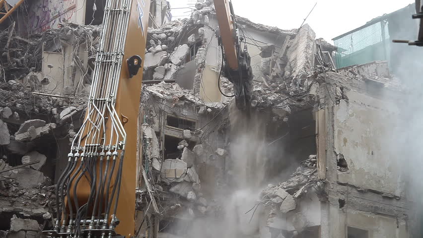 Demolition. Breaking a wall. Dust, debris and water. Detail. Falling debris. 