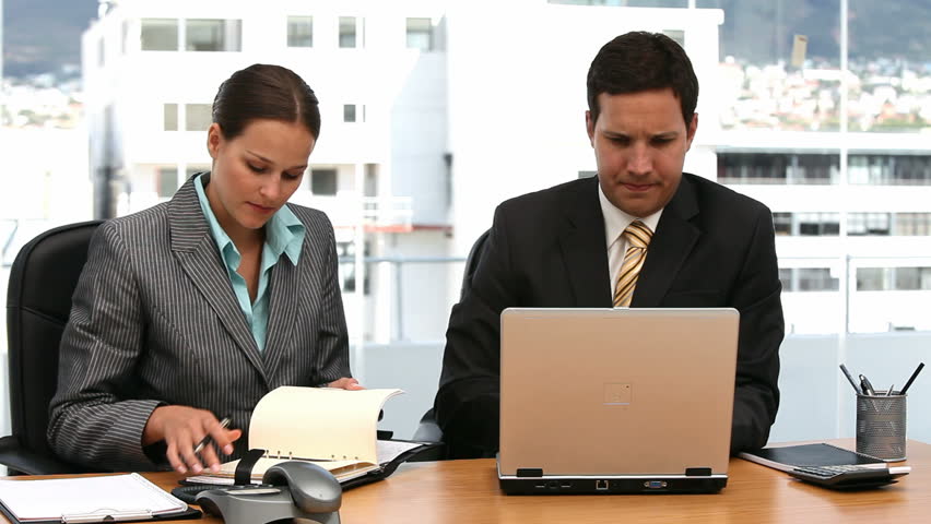 Two serious businesspeople working together in an office