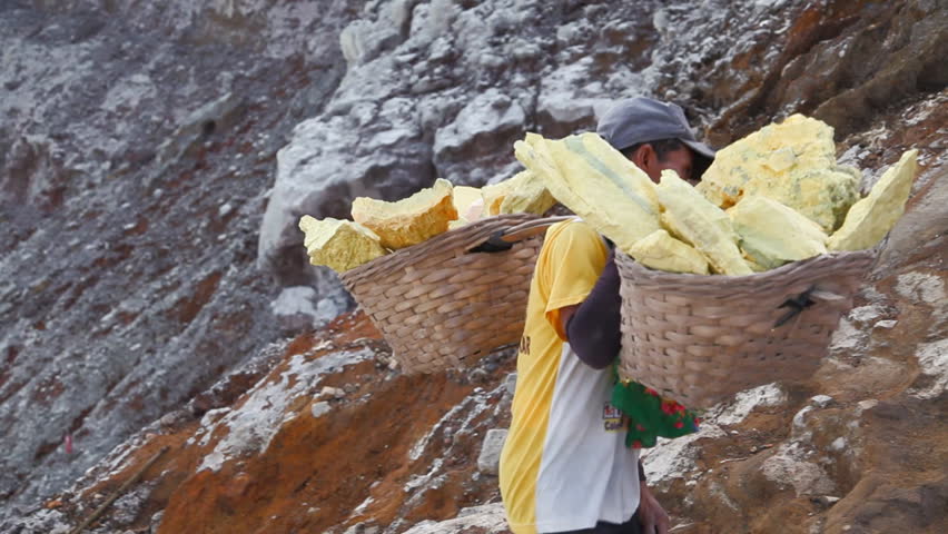 EAST JAVA, INDONESIA - June 18 : Worker lifts up the sulfur from the bottom of the crater June 18 2010 in Volcano, Java, Indonesia.