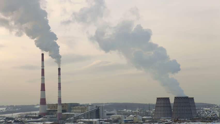 HD. Timelapse thermal power plant in the winter with two tall smoking chimneys and steam vapors from tanks, central heating city