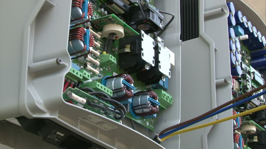 Worker is mounting cables inside inverter on solar power-plant.