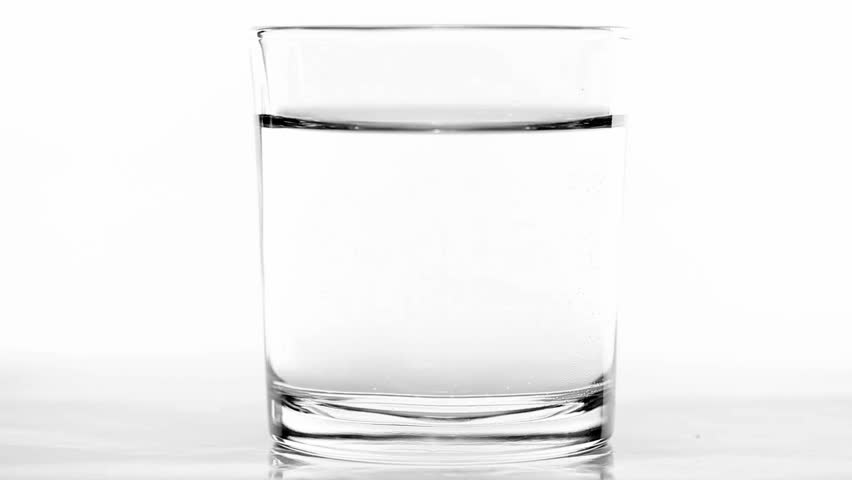 Aspirin or effervescent pill dropping into a glass of water and dissolving