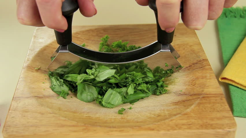 Dicing freshly picked homegrown herbs with a double edged chopper.