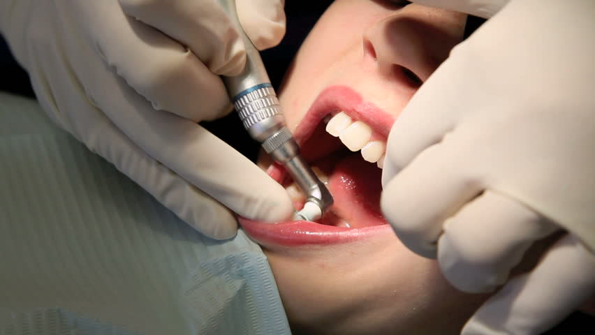 Young girl having her teeth cleaned at the dentist's