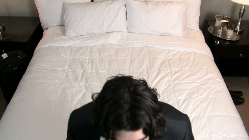 Businessman jumps backwards onto bed - HD