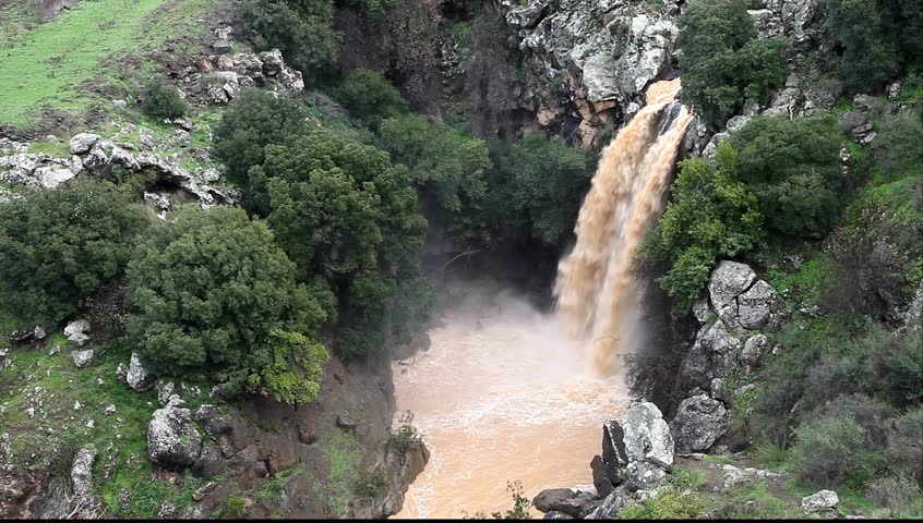 Banias Falls in the winter at the Golan Heights (Israel). Orange color of water because of washout of the earth from fields as a result of heavy rains. 