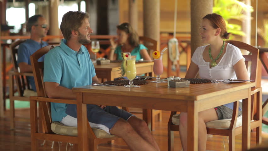 young couple receiving a tropical dessert from the waiter