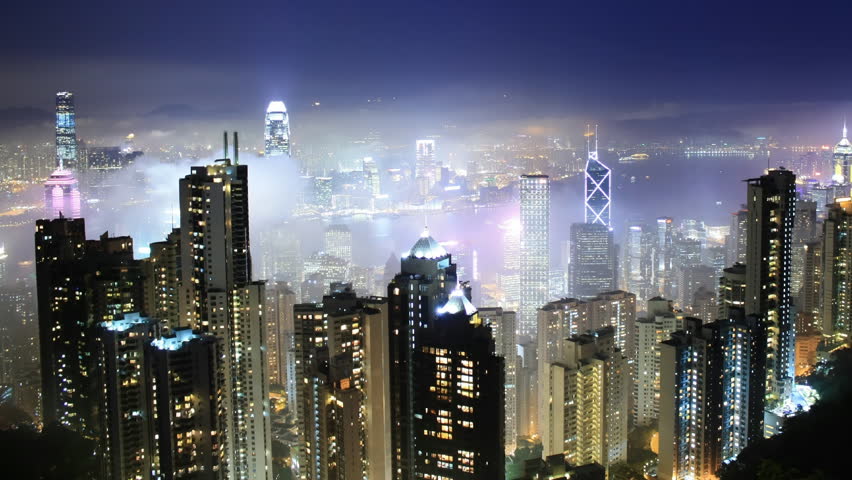 Time lapse Hong Kong skyline from famous Peak View at night. Fog comes into the city. 