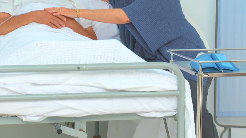 Woman taking her husband's temperature at the hospital