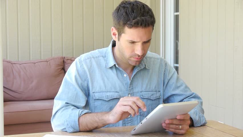 Man working at home with electronic tablet