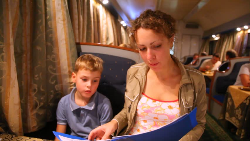 Mum and little son choose something in the menu in train