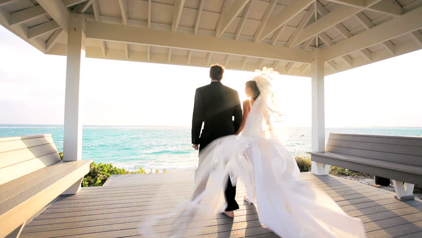 Attractive caucasian couple waiting for sunset after their paradise island wedding
