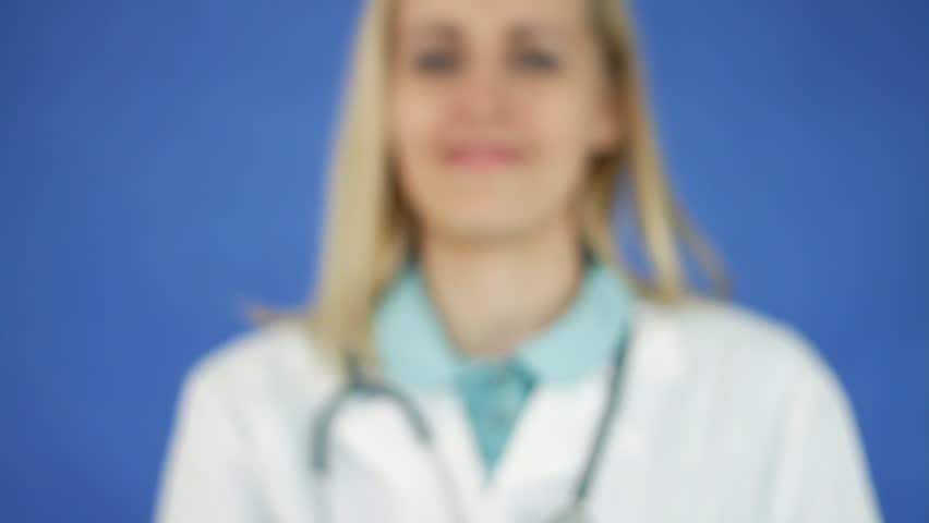 Female doctor hand offering pill on blue background 