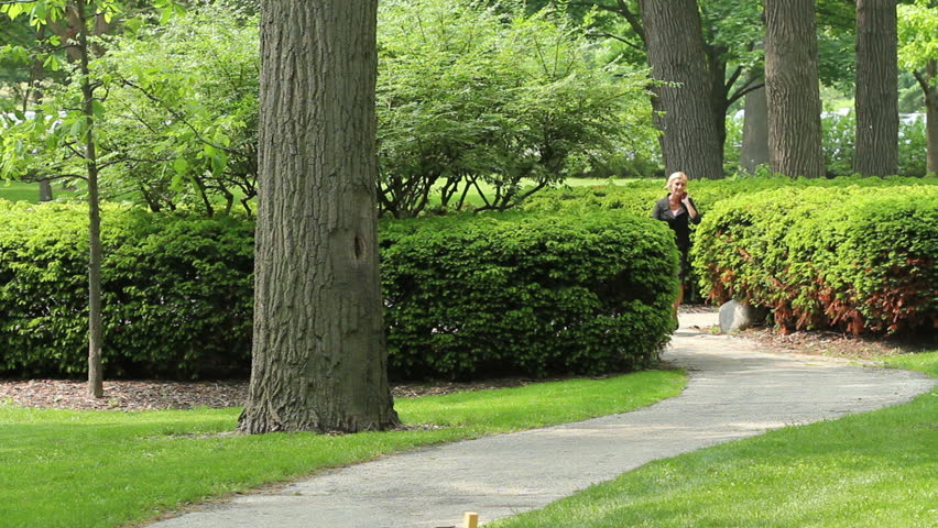 Business woman walking through park