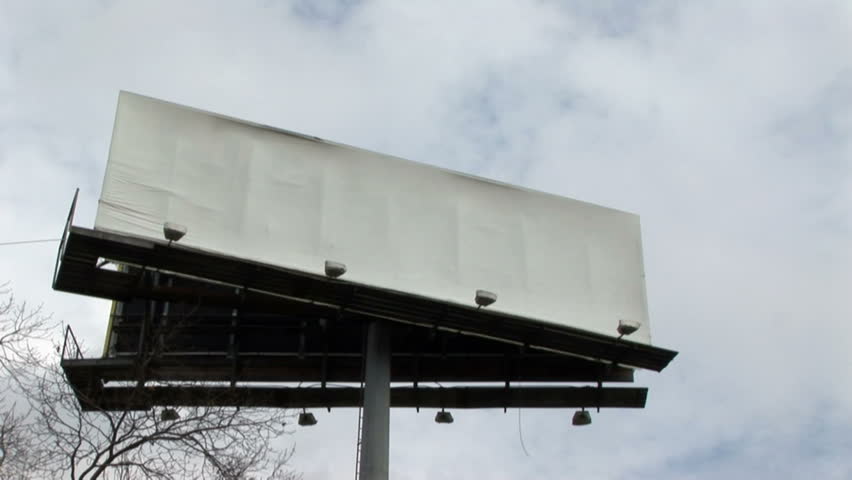 Time lapse of clouds moving over large white billboards which has copy space for your graphics or text.