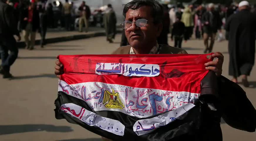 CAIRO - CIRCA JAN 2011: Man waves anti-mubarak flag, Tahrir Square, circa January 2011, Cairo, Egypt. Tahrir Square was the focal point of the 2011 Egyptian Revolution where demonstrations grew to 250,000 plus people by day 6, January 31, 2011. 