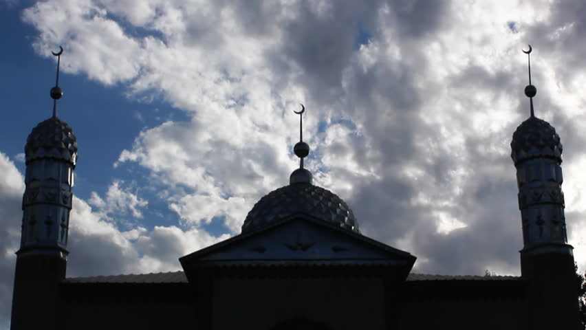 Fast clouds timelapse crossing behind a mosque minaret.