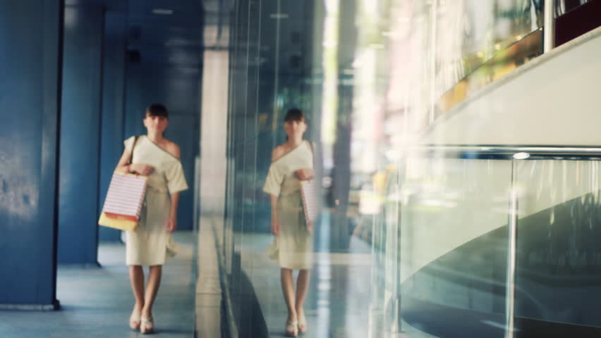 Attractive woman with shopping bags looking at shop window 