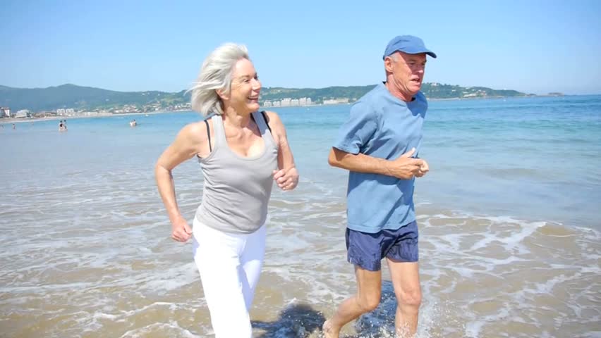 Senior couple jogging on a sandy beach