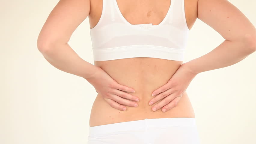 Fit woman massaging her back against a white background