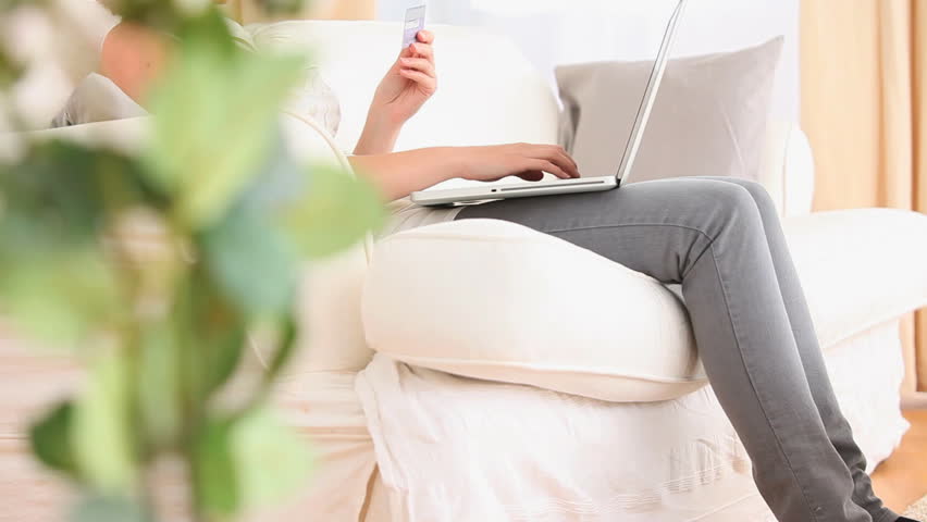 Beautiful woman buying online in her living room