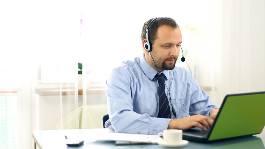 Young businessman, helpdesk consultant looking to camera