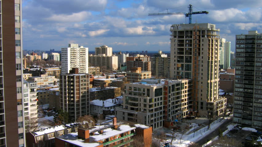 High Definition Time Lapse of a city scape with clouds moving quickly by and a construction crane. HD