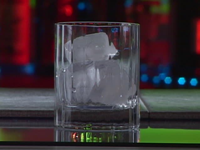 hard liquor and orange juice poured in a glass filled with ice