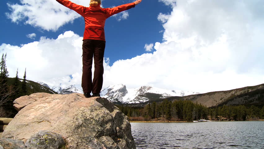 Lone female celebrates her achievement of hiking in a national park
