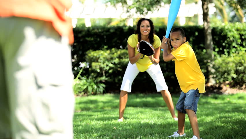 Young african american family playing baseball together in the park