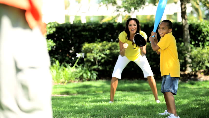 Young african american family playing baseball together in the park