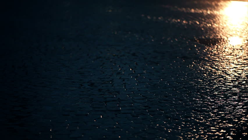 rain on street drops in headlights
