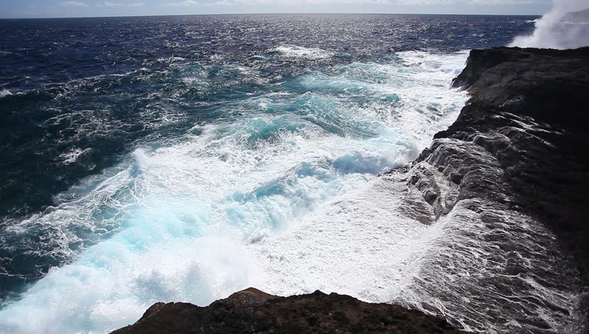 Ocean waves crash over a rocky shore.