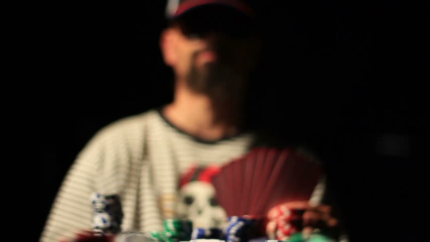 slow motion, man arrogantly playing a bunch of poker chips.  