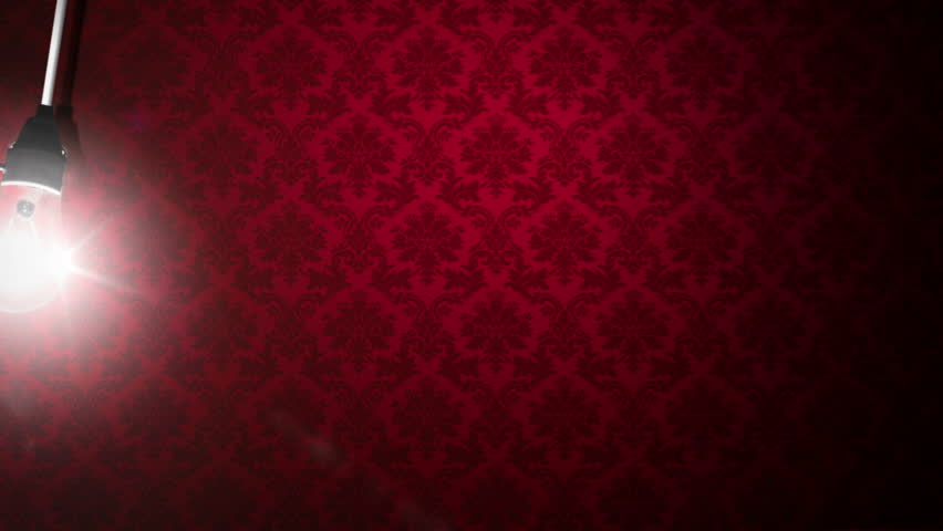 naked light bulb swinging against wallpaper wall 