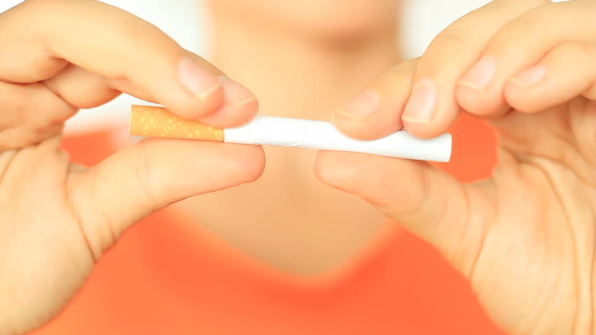 Females' hands breaking cigarette, close up