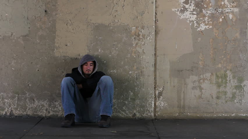 Homeless man watching business man walk by