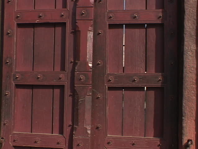 A wooden door opens to reveal the Taj Mahal.