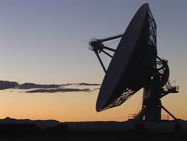 A satellite dish sits before a colorful sky in New Mexico.