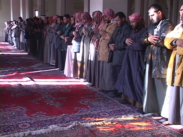 BAGHDAD, IRAQ - CIRCA 2003: Muslims pray in a mosque of war-torn circa 2003 in Baghdad, Iraq.