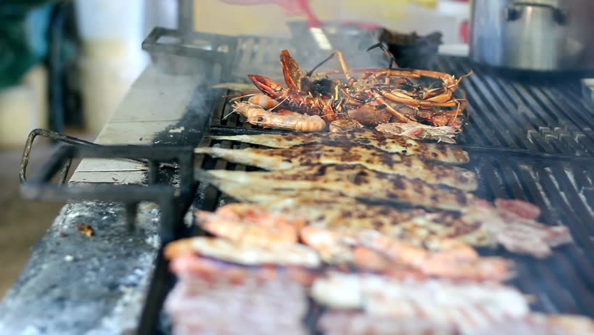 Grilling lobsters, fish and shrimps on a barbecue.  HD 1080i. 
