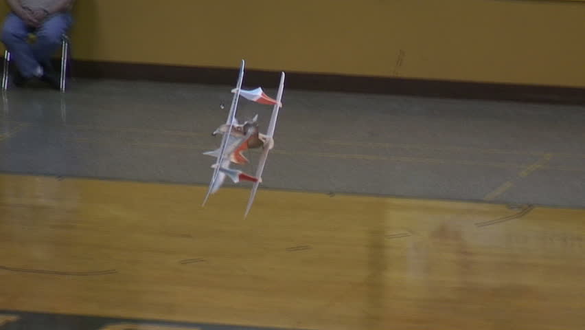 Radio-controlled foam model airplane performing aerobatic tricks at the competition venue