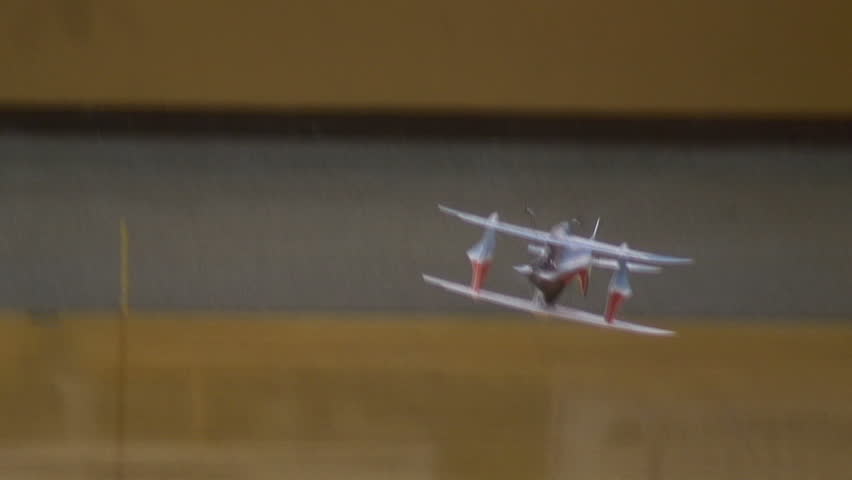 Radio-controlled foam model airplane performing aerobatic tricks at the competition venue