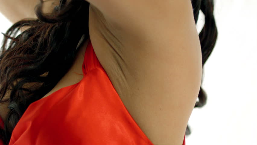 A beautiful Latino Woman dances in a red dress against a white background. She plays with a white scarf as the wind blows through her hair.