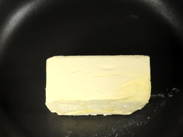 Time lapse as a cube of butter melts in a skillet.