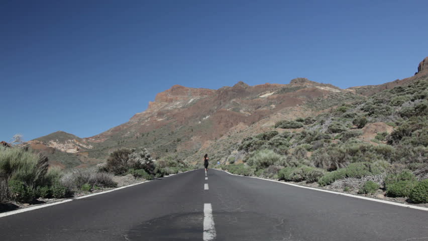 Runner. Woman running in dramatic landscape. female fitness model jogging on Tenerife, Teide, Canary Islands, Spain.