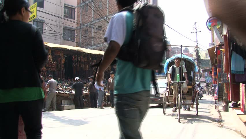 KATHMANDU - CIRCA 2010: People, cars and bikes circulate through the city circa 2010 in Kathmandu.