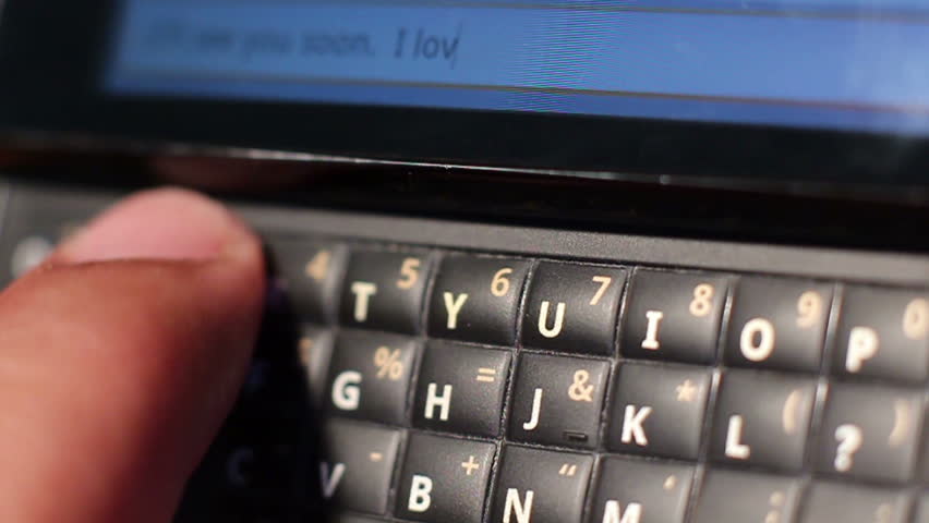 HD macro footage of a QWERTY keyboard smart phone with the message "I love you." being texted