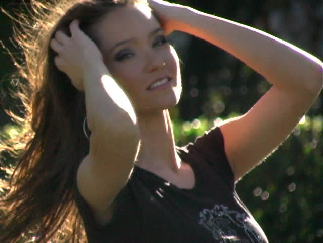 Close-up of a beautiful brunette outdoors on a breezy summer day.