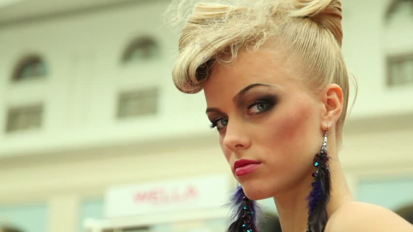 MOSCOW - OCTOBER 2: Blonde with fanciful hairdo and plum earring at XVII International Festival World of Beauty 2010 in exhibition complex Gostiny Dvor, on October 2, 2010 in Moscow, Russia. 